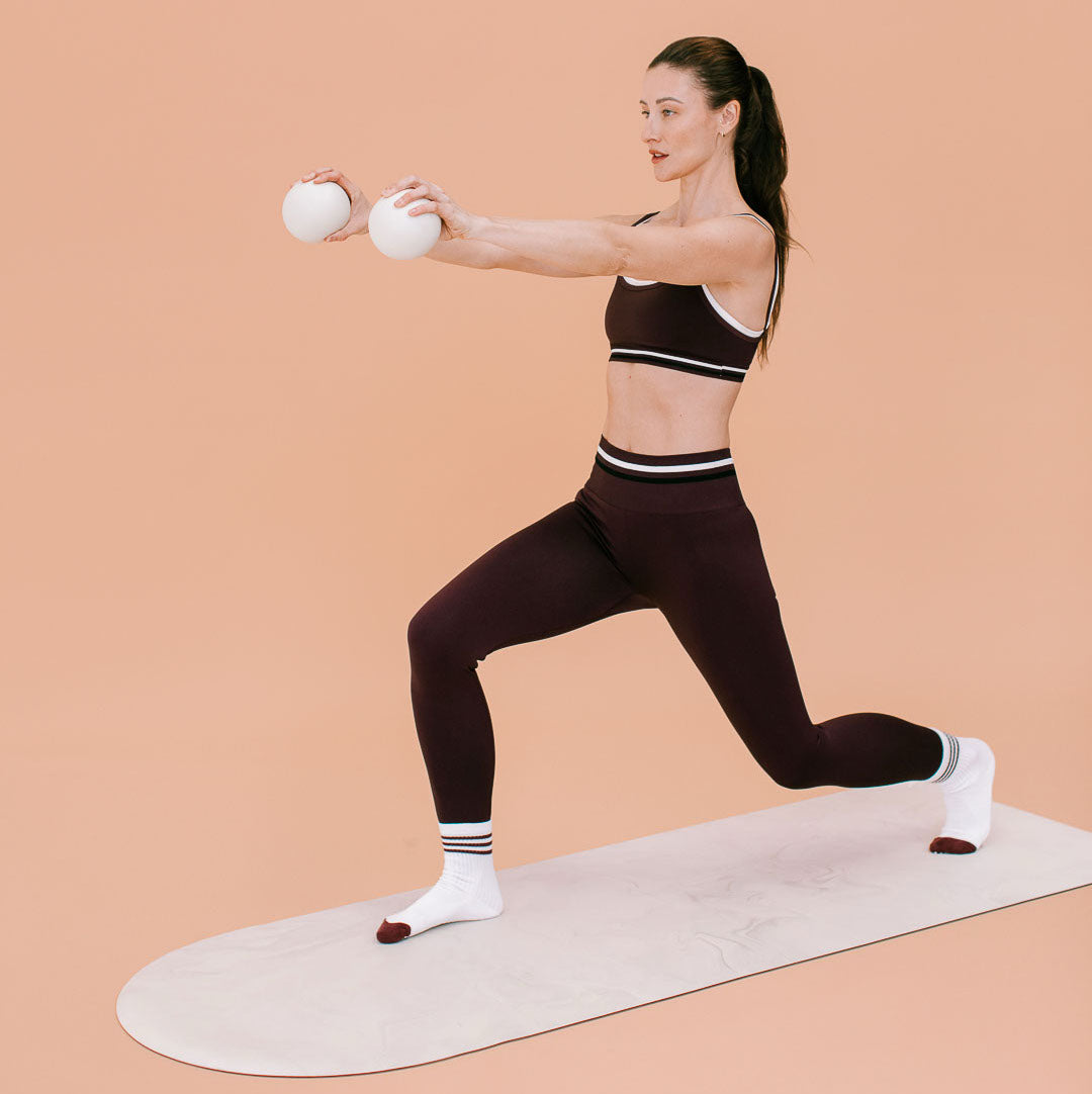 Beige Pilates Toning Balls Held in Lunge on Mat - On Model Lifestyle | Your Reformer