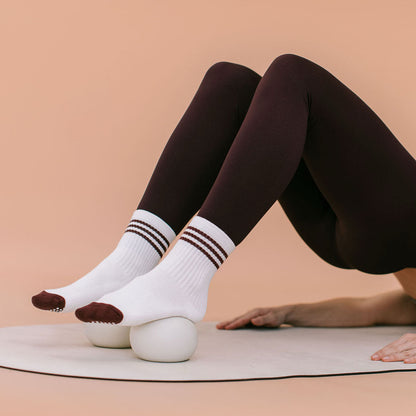 Beige Pilates Toning Balls Under Feet in Mat Exercise - On Model | Your Reformer