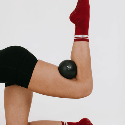 Black Pilates Toning Ball Used Between Knees in Bridge Pose - On Model | Your Reformer