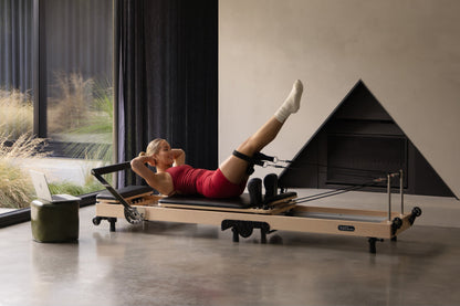 YR Original Folding Reformer - Woman Practicing Pilates in Modern Living Room | Your Reformer